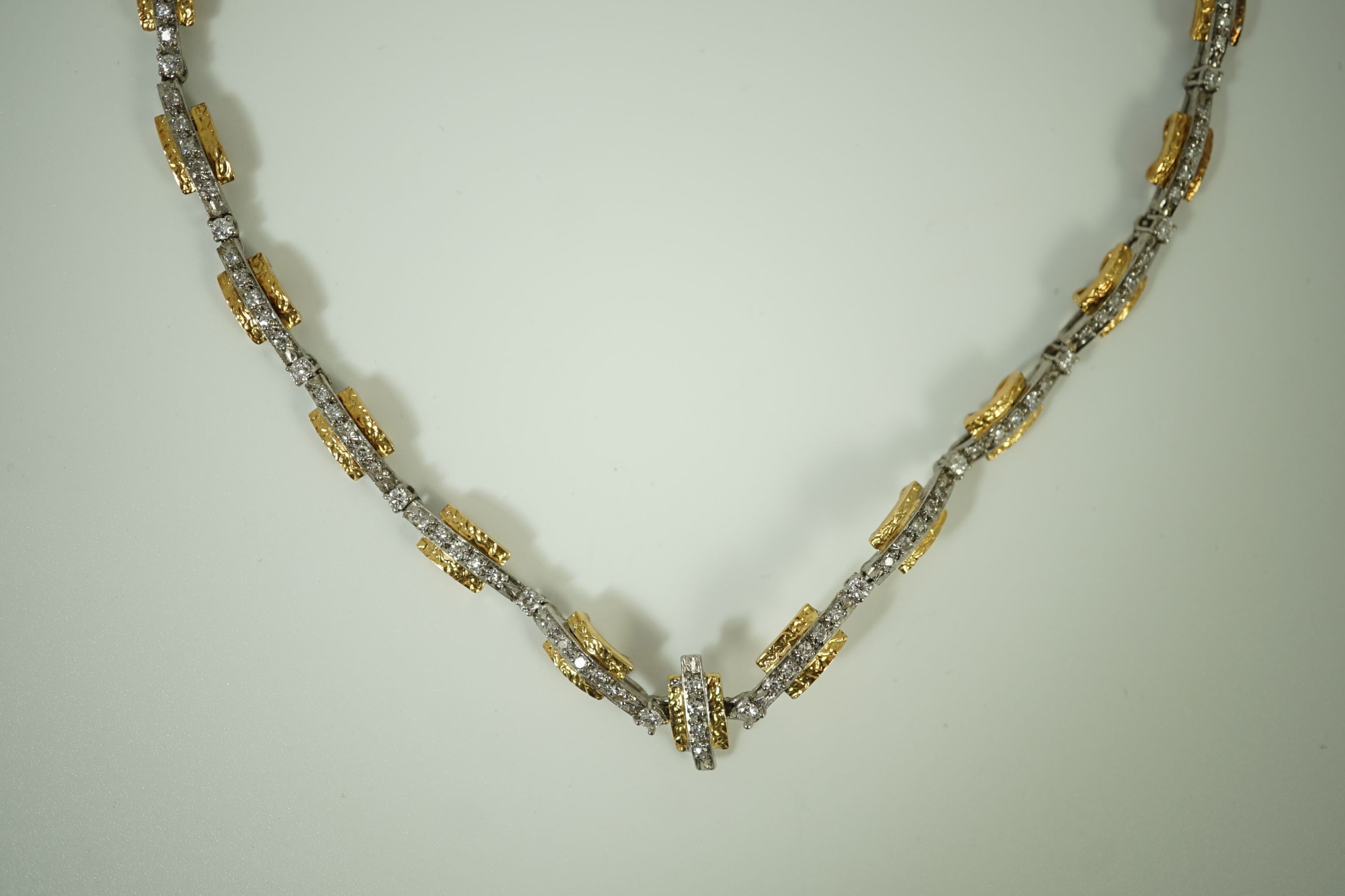 A 20th century two colour gold and diamond set necklace